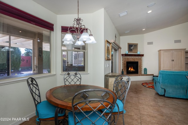 dining room featuring tile patterned flooring, lofted ceiling, and an inviting chandelier