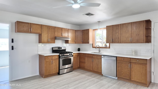 5640 N Burke Blvd, Rimrock, AZ 86335 - kitchen with appliances with stainless steel finishes, a sink, under cabinet range hood, and brown cabinetry