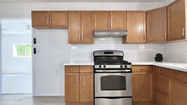 5640 N Burke Blvd, Rimrock, AZ 86335 - kitchen with stainless steel gas stove, under cabinet range hood, and brown cabinetry