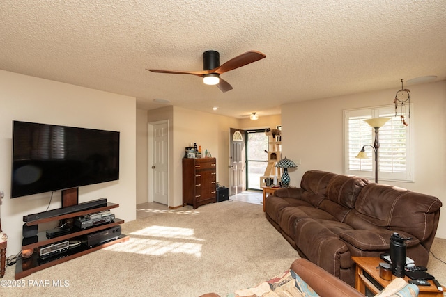 living room with carpet floors, ceiling fan, and a textured ceiling