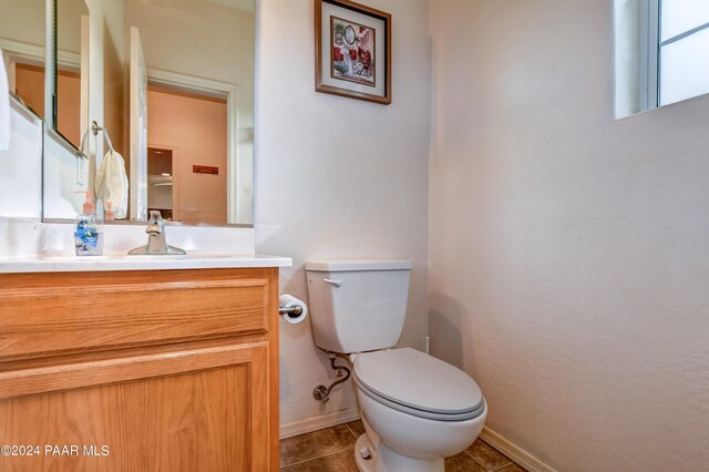 bathroom with tile patterned flooring, vanity, and toilet