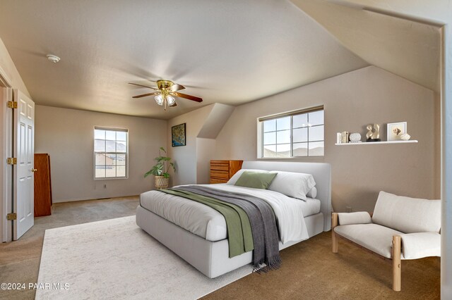 bedroom featuring light colored carpet, vaulted ceiling, and ceiling fan