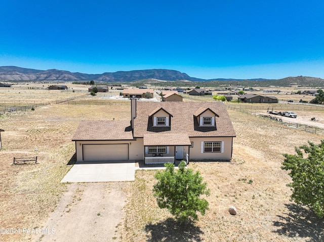 view of front of home featuring a mountain view, a porch, and a garage