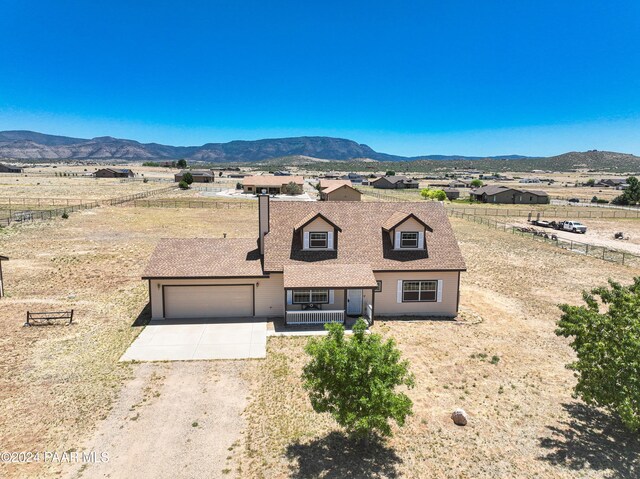 view of front of home featuring a mountain view, a porch, and a garage