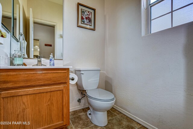 bathroom with toilet, vanity, and tile patterned floors