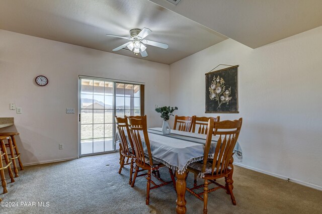 carpeted dining room with ceiling fan