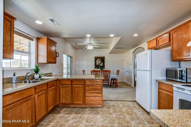 kitchen featuring kitchen peninsula, ceiling fan, plenty of natural light, and sink