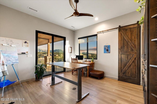 office area featuring baseboards, ceiling fan, visible vents, and light wood-style flooring