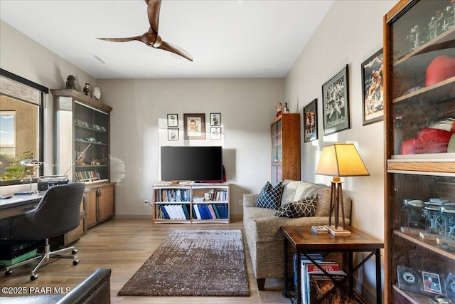 office featuring ceiling fan, wood finished floors, and visible vents