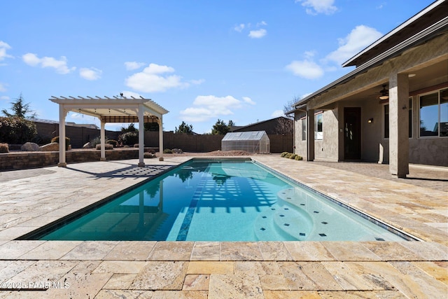 view of pool with an outbuilding, a ceiling fan, a pergola, a patio, and a fenced backyard