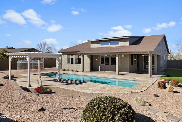 back of house with stucco siding, a pergola, a patio, a fenced backyard, and a fenced in pool