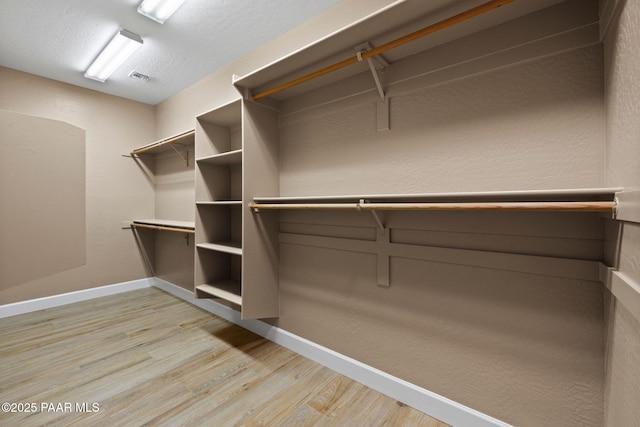 spacious closet featuring light wood-style flooring and visible vents