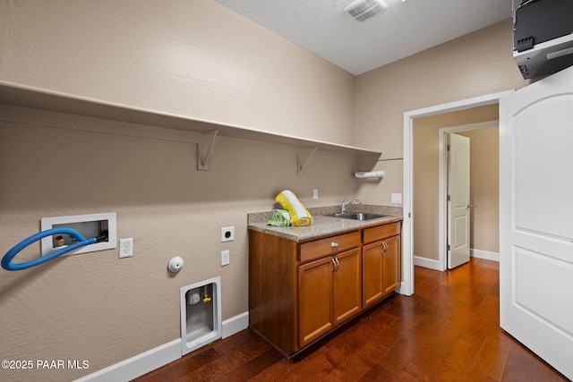 clothes washing area featuring visible vents, electric dryer hookup, washer hookup, a sink, and hookup for a gas dryer