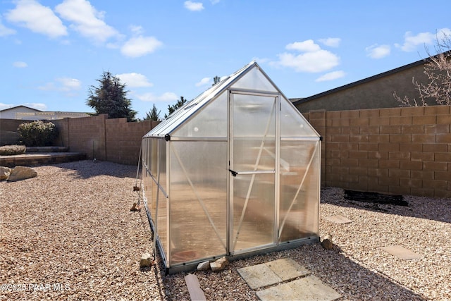 view of greenhouse with a fenced backyard