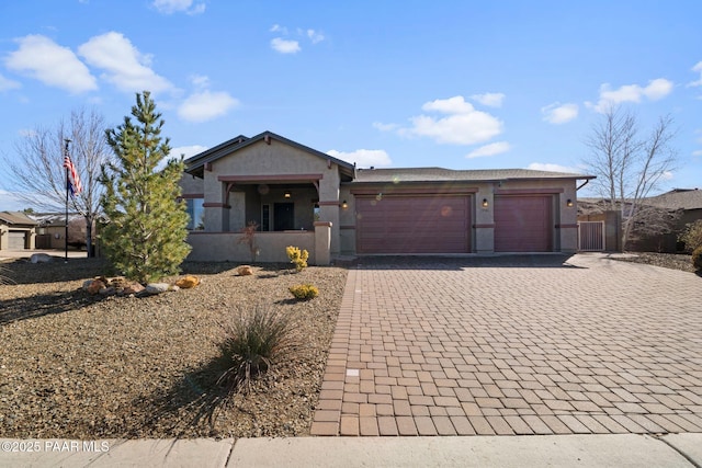 view of front facade featuring decorative driveway, an attached garage, and stucco siding