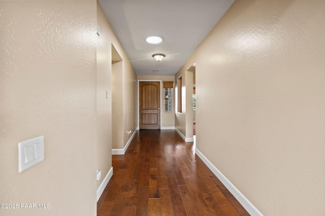 corridor featuring hardwood / wood-style floors and baseboards