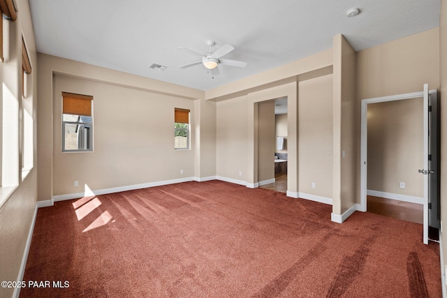 unfurnished bedroom featuring visible vents, baseboards, ensuite bathroom, and carpet