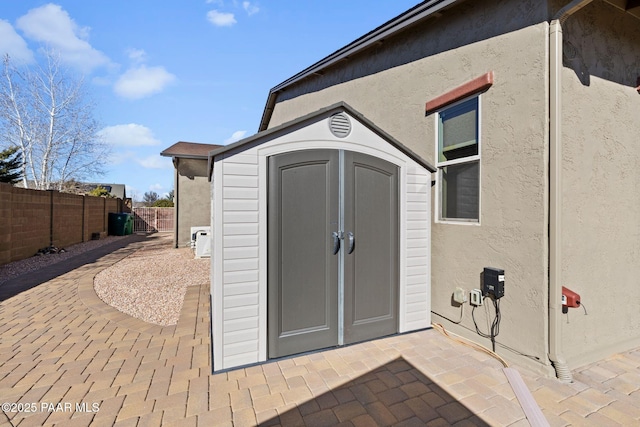 view of shed featuring fence