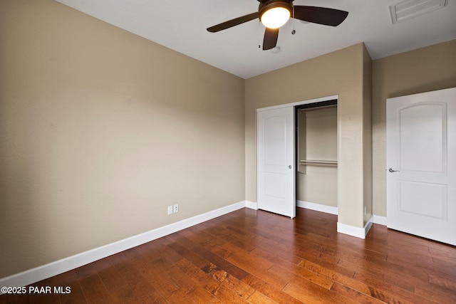 unfurnished bedroom featuring visible vents, a ceiling fan, hardwood / wood-style flooring, a closet, and baseboards