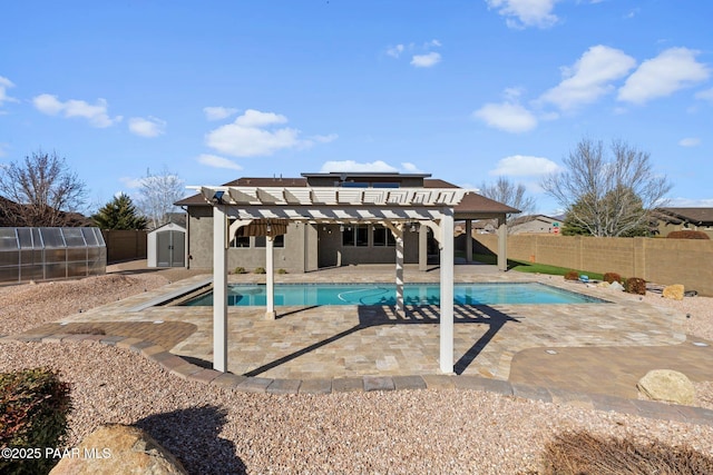 view of pool featuring an outbuilding, a patio, a shed, a fenced backyard, and a pergola