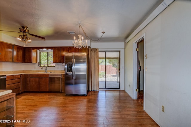 kitchen with light countertops, dark wood-style flooring, appliances with stainless steel finishes, and a sink