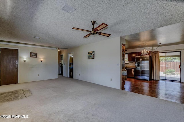 7874 E Siesta Ln, Prescott Valley, AZ 86314 - unfurnished living room featuring carpet floors, a textured ceiling, a chandelier, and ceiling fan