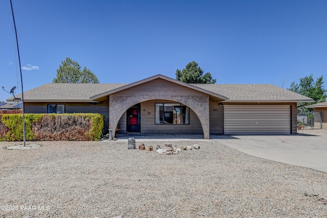 view of front facade featuring a garage, covered porch, driveway, and a shingled roof