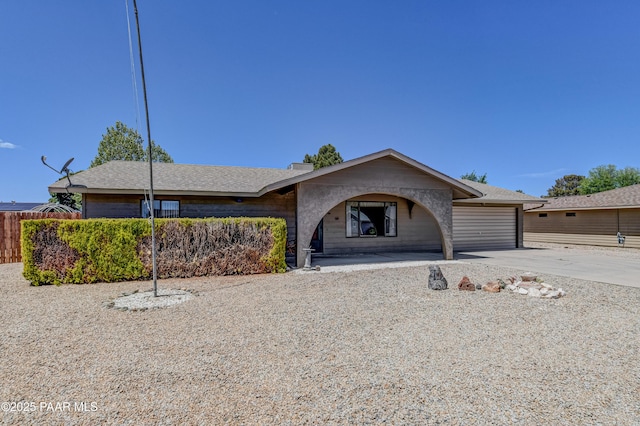 view of front of property featuring roof with shingles, an attached garage, and driveway