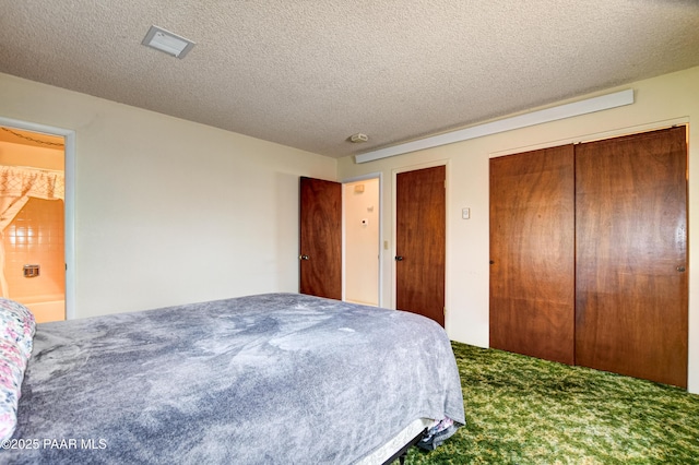 bedroom featuring carpet, two closets, a textured ceiling, and visible vents