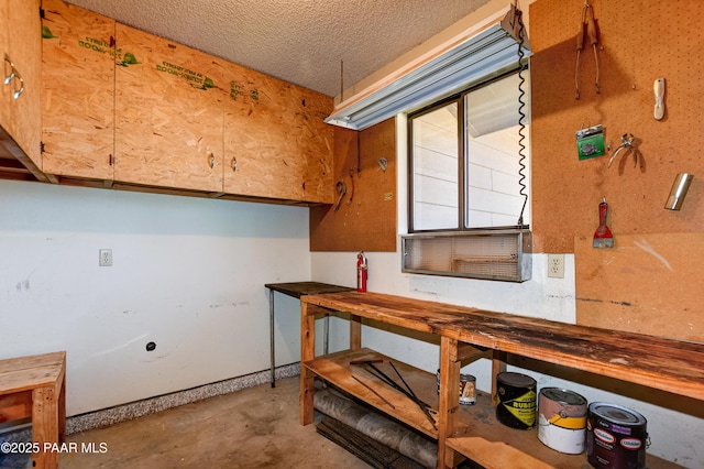 basement with a textured ceiling and a workshop area
