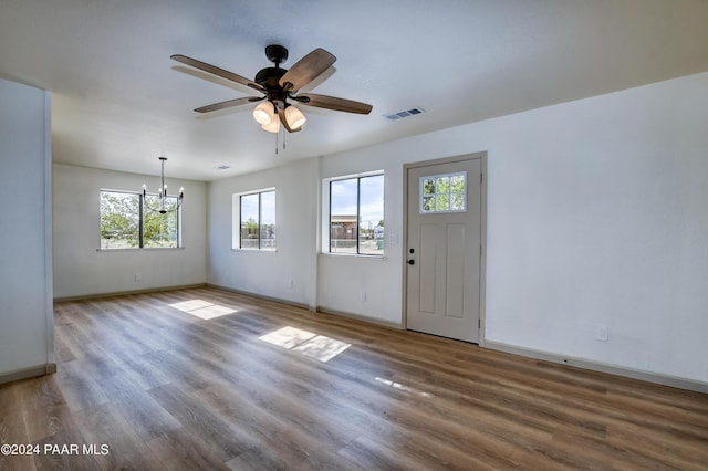 interior space featuring hardwood / wood-style floors, ceiling fan with notable chandelier, and a healthy amount of sunlight