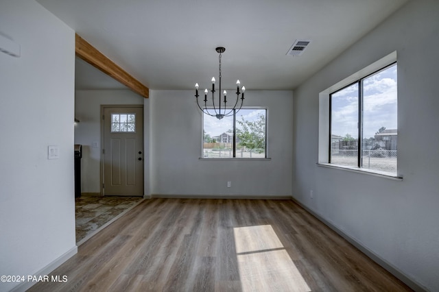 unfurnished dining area featuring light wood-type flooring and an inviting chandelier