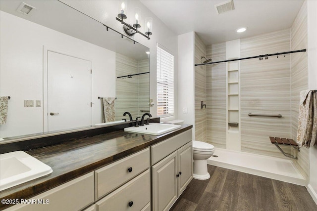 1445 S Table Mountain Rd, Chino Valley, AZ 86323 - full bath featuring double vanity, a tile shower, toilet, wood finished floors, and recessed lighting