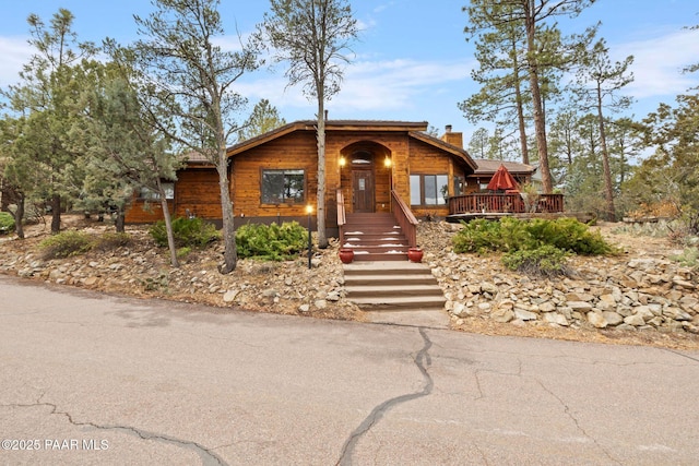 view of front of home featuring a wooden deck and a chimney