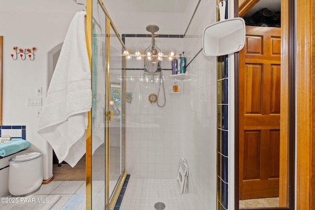 full bath with a shower stall, toilet, and an inviting chandelier