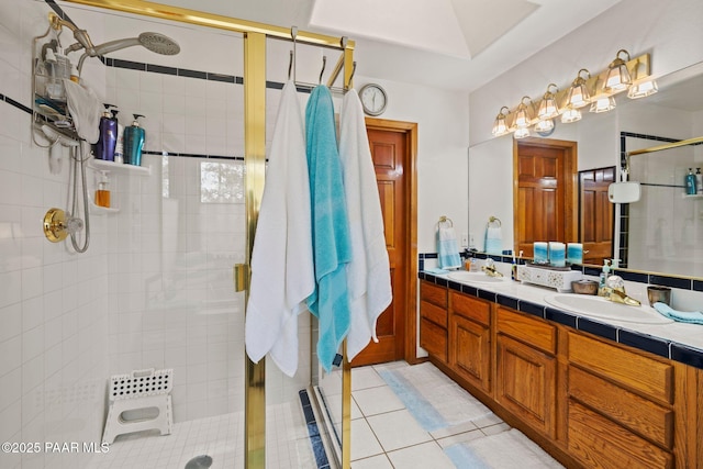 bathroom with a sink, a stall shower, double vanity, and tile patterned floors