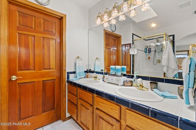 bathroom with a sink, visible vents, a stall shower, and double vanity