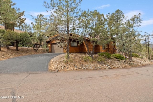 view of front of home with aphalt driveway and a garage