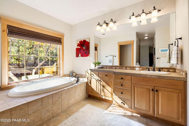 bathroom with tile patterned flooring, vanity, and tiled tub