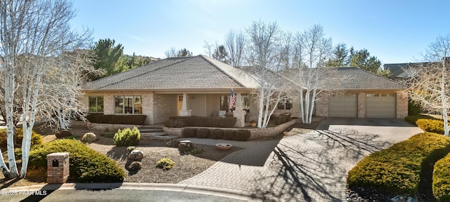 single story home featuring a porch and a garage