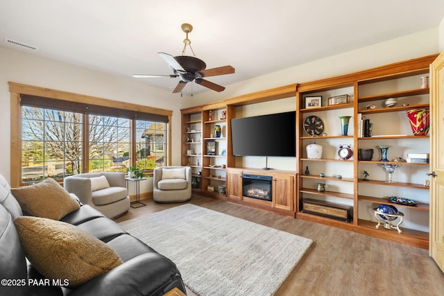 living room with ceiling fan and light wood-type flooring