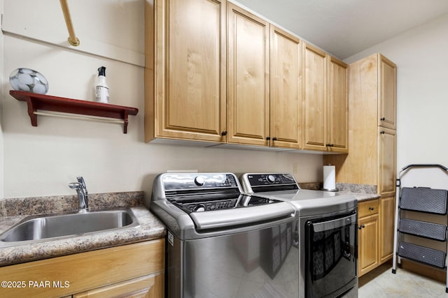 laundry room with cabinets, washer and clothes dryer, and sink