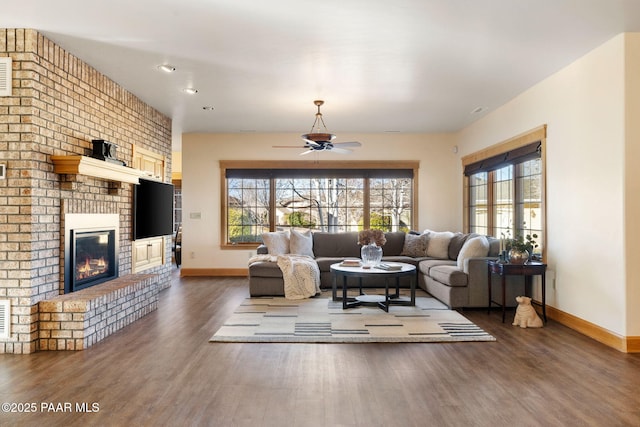 living room featuring a fireplace, dark hardwood / wood-style flooring, and ceiling fan