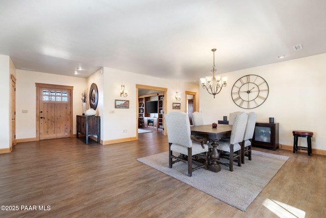 dining space with a notable chandelier and dark hardwood / wood-style flooring