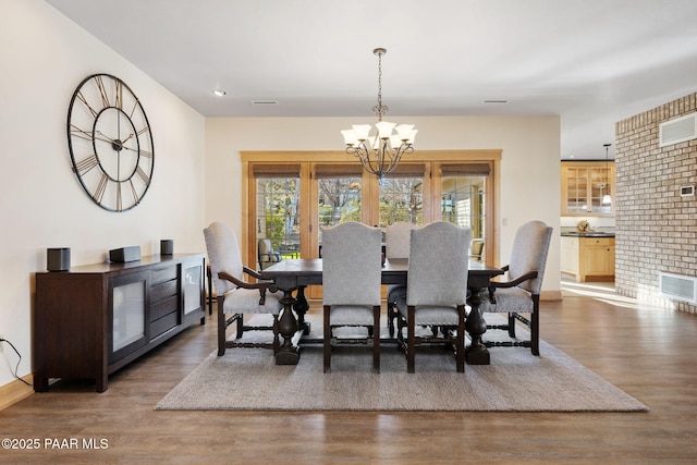 dining space featuring dark hardwood / wood-style floors and a chandelier