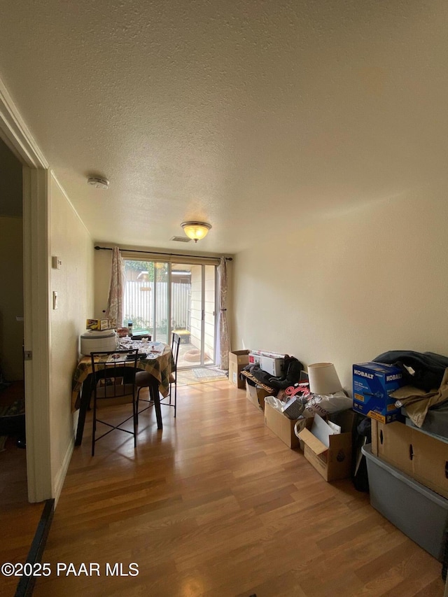 dining area featuring a textured ceiling and wood finished floors