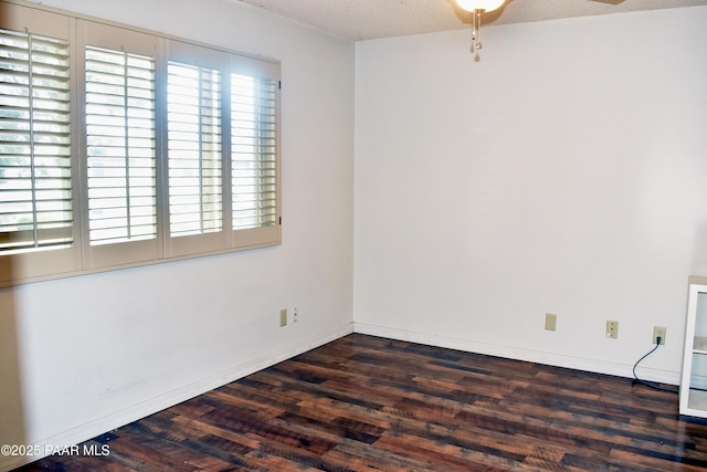 spare room with baseboards, ceiling fan, and wood finished floors