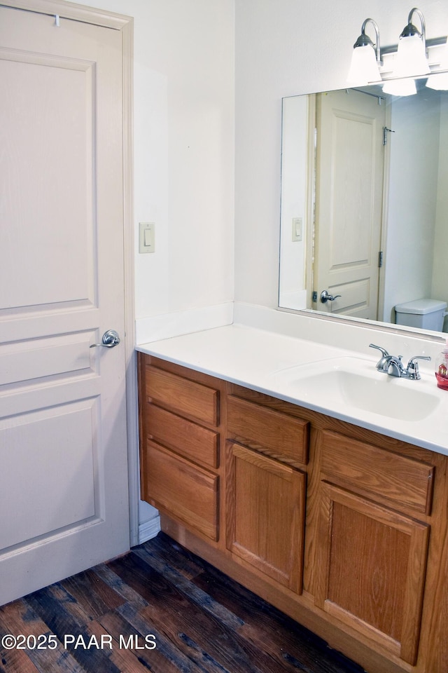 bathroom with vanity, toilet, and wood finished floors