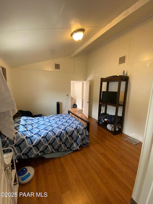 bedroom featuring visible vents, lofted ceiling with beams, and wood finished floors