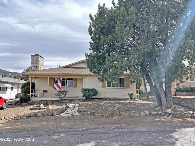 view of front of home with a porch and a chimney